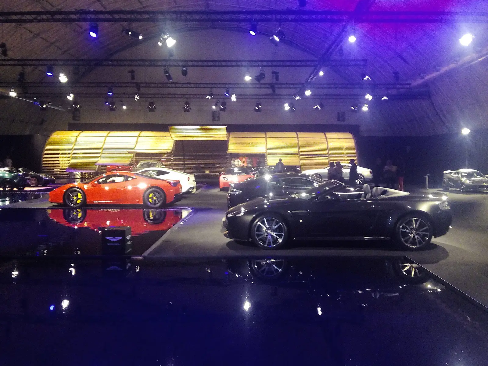 Cars displayed on a lit stand at the Barcelona car show in 2015
