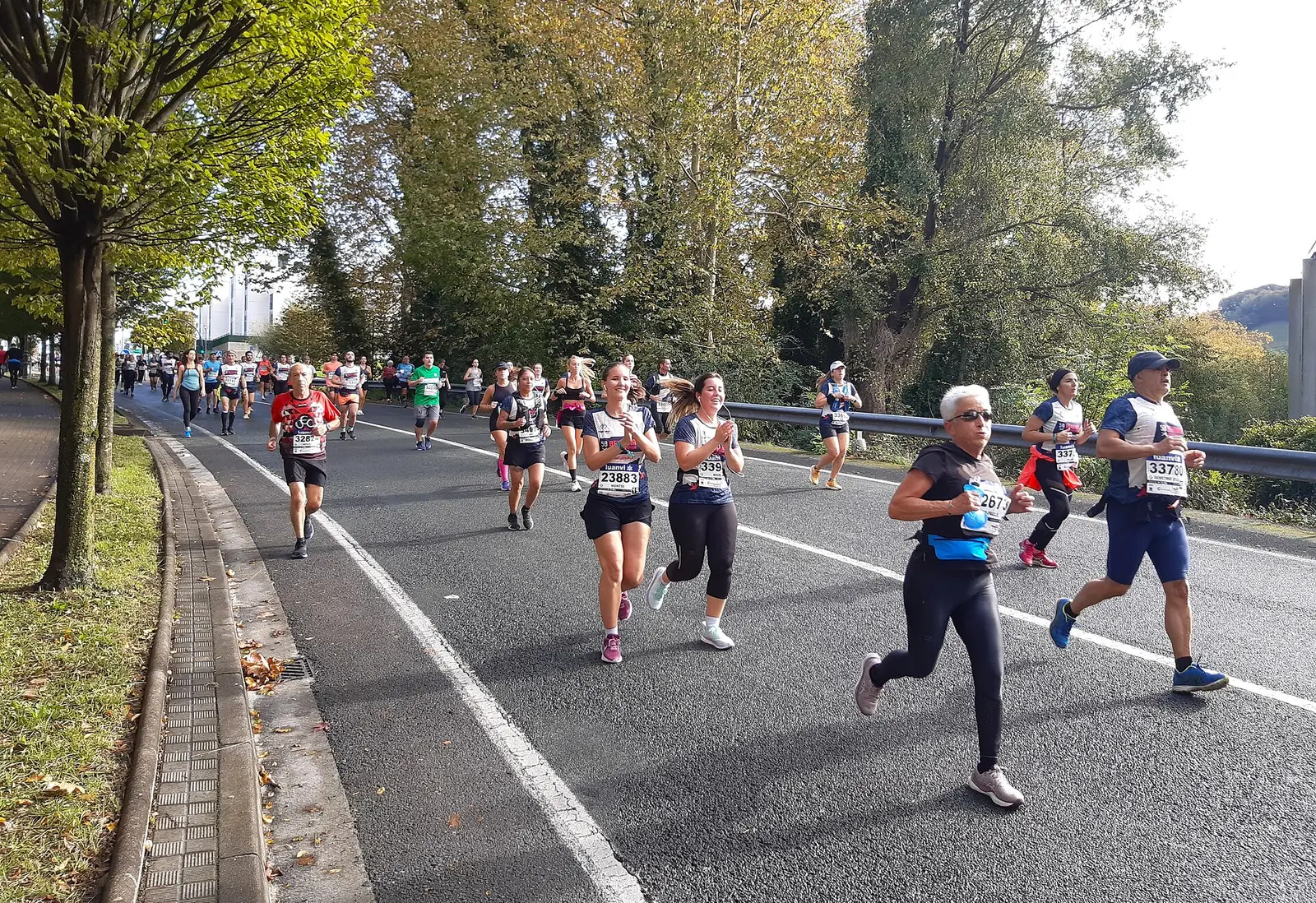 Runners on a tree lined road during the Behobia San Sebastian race in 2023