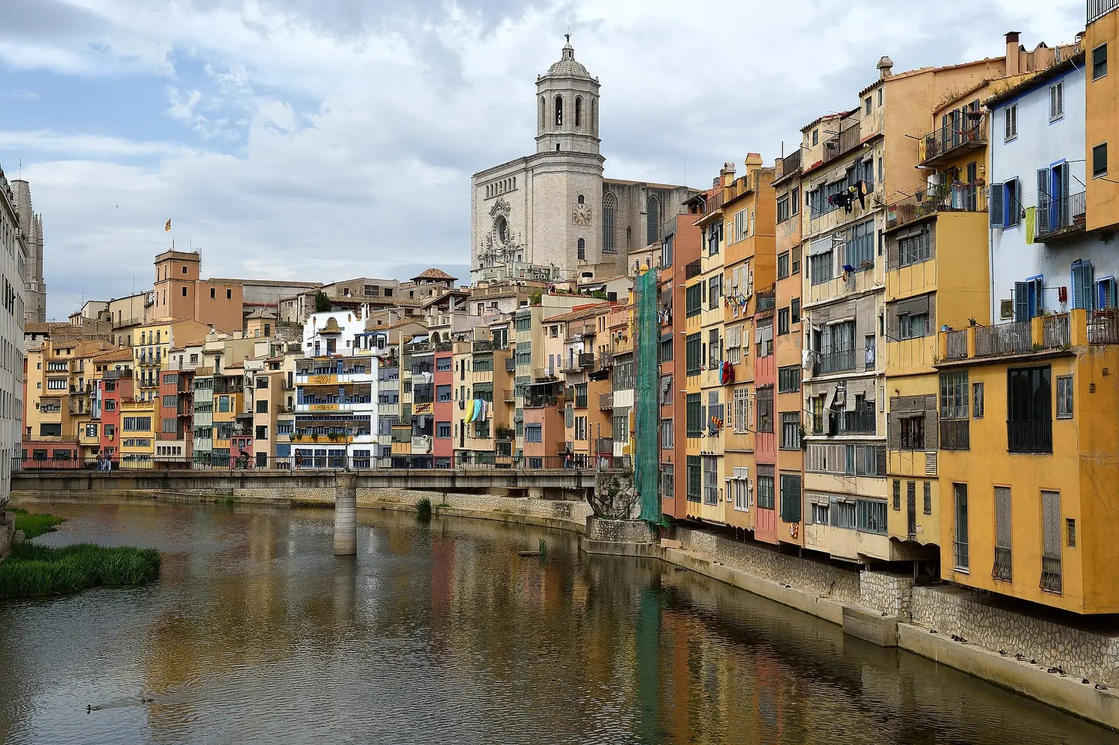 Colourful houses along the Onyar river in Girona with the cathedral behind